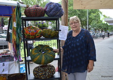 Marijke Visser met naast haar stoofkussens uit Ghana, die in de Wereldwinkel verkrijgbaar zijn. 