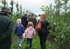 De bezoekers volgens Pieter Jans door de boomgaard.