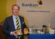 Edward Vonk met de biologische paddenstoelen van Banken Champignons. Zoals op de achtergrond te zien is voert het bedrijf sinds kort een nieuwe, frisse huisstijl.