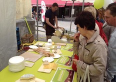 Paul Verbeke van BioForum snijdt bij zijn kraam op verzoek de kazen van Damse kazen, Capra en de winnaar van de smaakaward Het Hinkelspel.