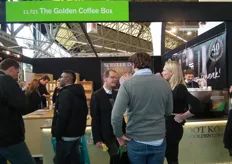 Barend Boot (midden) van The Golden Coffee Box druk in gesprek met twee bezoekers.