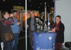 Bezoekers proeven gevitaliseerd water van Aqua Aurora, met Henk en Gerda Pannekoek.
