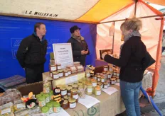 "Imker Thomas Bekker (links) vertelde de marktbezoekers alles over de honingproducten van De Beehive uit Stampersgat. "Onze honingproducten zijn niet biologisch gecertificeerd, dat is onmogelijk in Nederland", vertelt Thomas die al bijna tien jaar imker is."