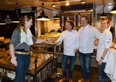Jochem Keune biedt een bezoeker lekkers aan van Le Perron. Naast hem zijn collega's Olaf en Judith Heinen