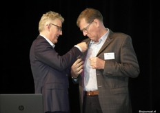 Jan Zomerdijk krijgt als eerste het speldje opgespeld.