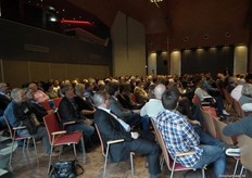 De vrij volle zaal vanaf de zijkant gezien.