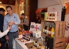 Sander van Leeuwen geeft een bezoeker een klein bekertje met 'Eerste hulp van Schulp' (Vruchtensappen).