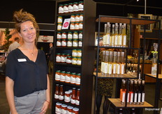 Maril Dings bij Foodelicious. Achter haar een kast vol bio-producten van het merk Biagi. 