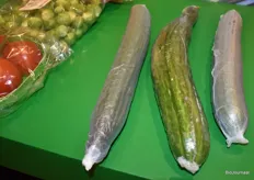 De middelste komkommer is verpakt in gangbare verpakking en de buitenste in de biologische verpakking van Oerlemans Packaging.